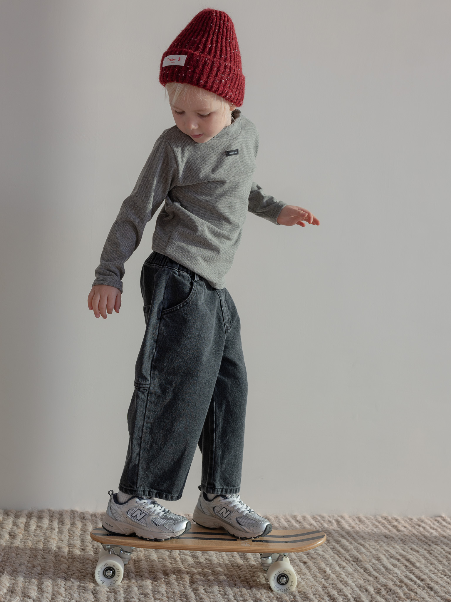 Donkere jeans met een coltruitje in charcoal en rode muts